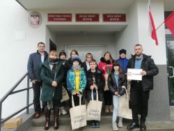 Uczniowie, Dyrektor Renata Paluszkiewicz, Przemysław Łobacz oraz Wójt Gminy Wyryki Mirosław Torbicz stoją przed wejściem do Urzędu Gminy Wyryki
