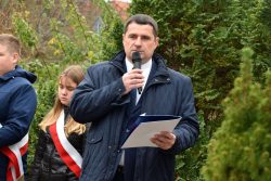 Wójt Gminy Wyryki Mirosław Torbicz przemawia do uczestników wydarzenia, w jednej dłoni trzyma mikrofon, w drugiej otwartą teczkę