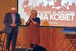 Na scenie stoi Pan Janusz Pruniewicz oraz Pani Aniela Leszczyńska dziękując organizatorom za koncert, w tle plakat wydarzenia
