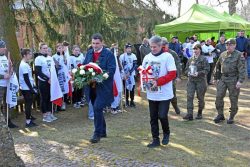 Wójt Gminy Wyryki Mirosław Torbicz oraz Wiesław Holaczuk składają kwiaty i znicz przy pomniku upamiętniającym powstańców styczniowych
