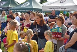 Duża grupa osób, w tym dzieci i dorosłych, zgromadzonych na otwartej przestrzeni. W tle widoczne są namioty promocyjne: jeden ciemnozielony z napisem „Zespół Lubelskich Parków Krajobrazowych” oraz biały z adresem internetowym „www.poleskipn.pl”.